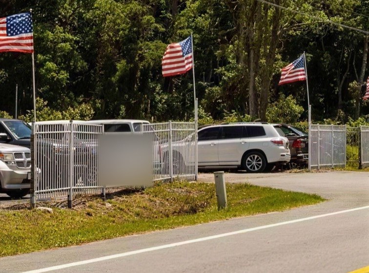 Steel perimeter fence and flags at the Jacksonville yard entrance.